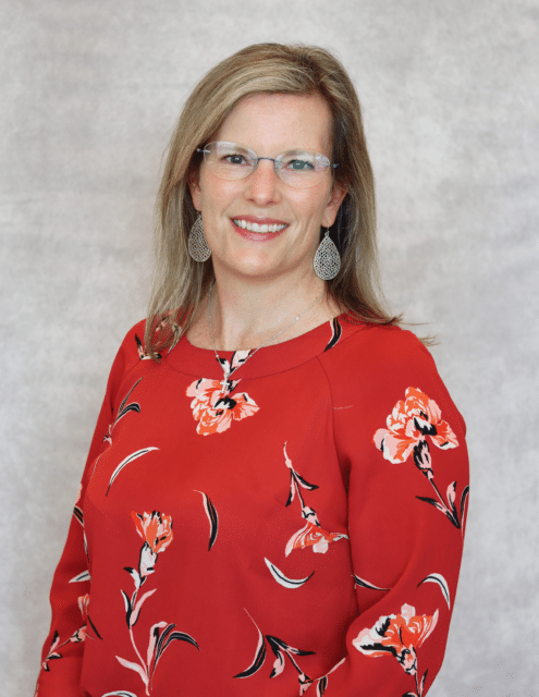 Chandler K. Hunt, PA-C, wears a red floral blouse and glasses, smiling against a neutral background.