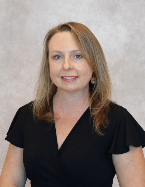 Nikki Morgan, APRN-C, smiling in a professional black dress against a neutral background.