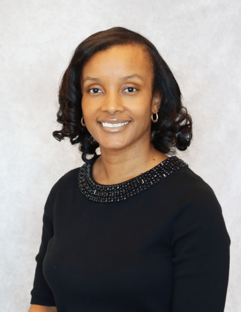 Alexis, a professional in healthcare, wearing a black beaded neckline top, smiles warmly.