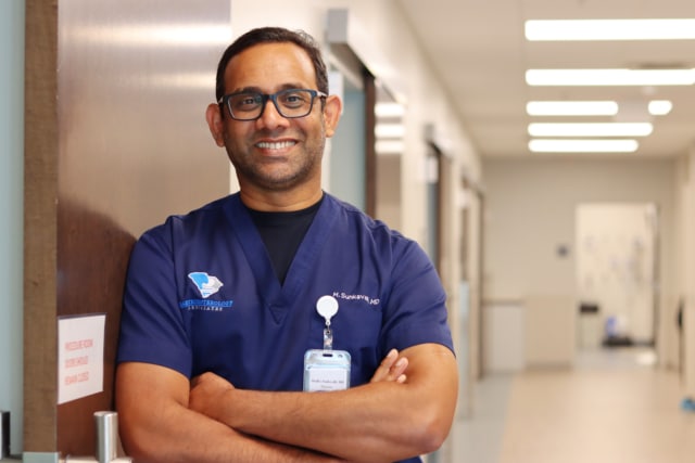 Dr. Madhusudhan Sunkavalli leaning against a door in the Gastroenterology Associates' office. 