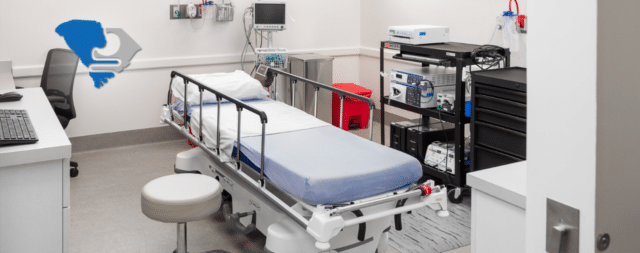 Medical examination room with a bed, monitor, and equipment for colon cancer screening by your primary care provider.